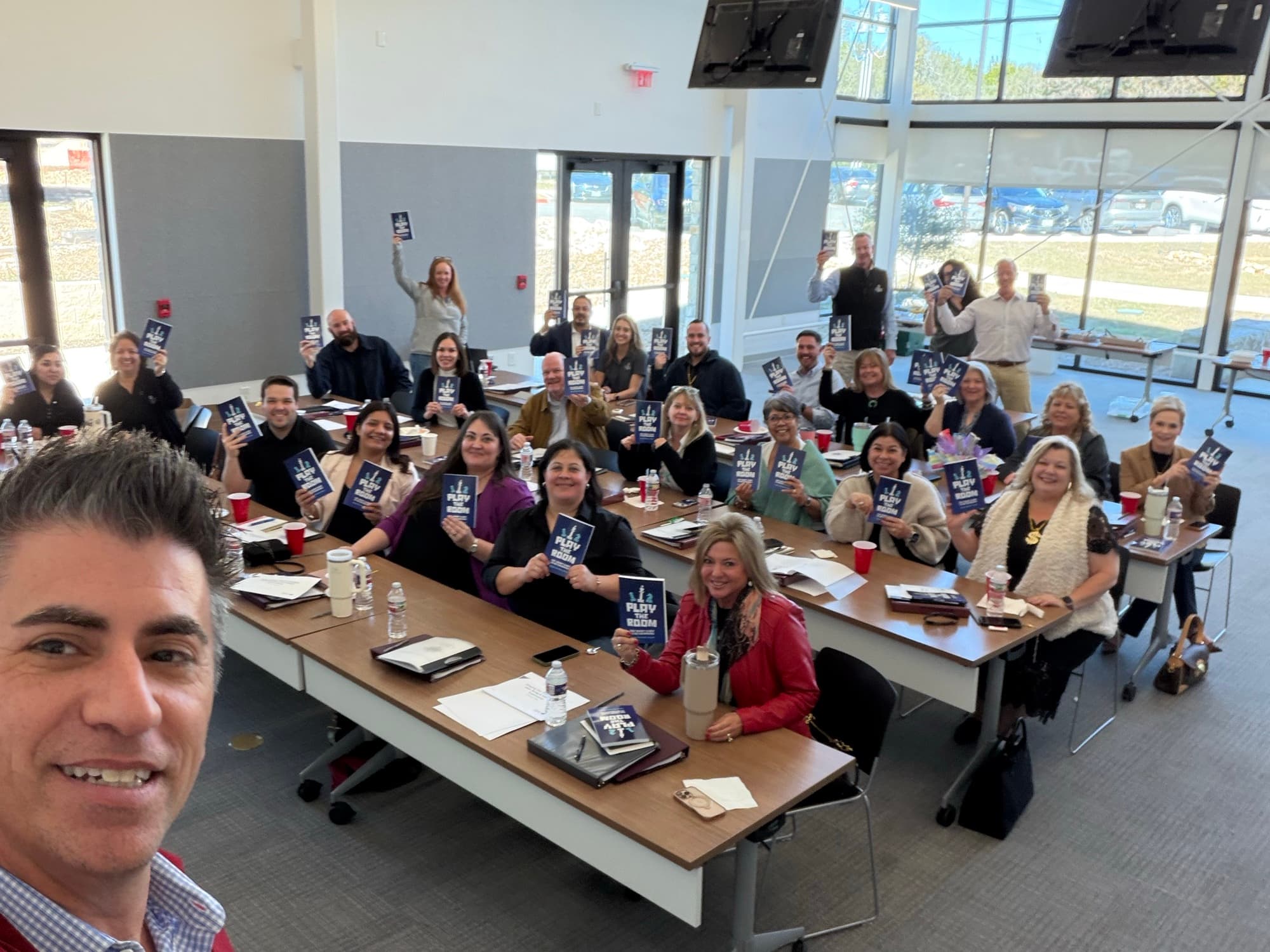 Dagan with a room full of attendees holding Play the Room