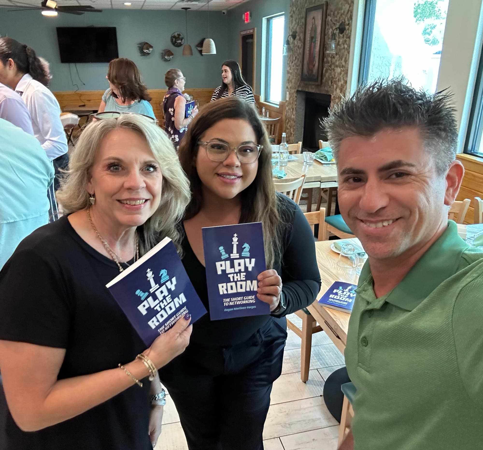 Dagan Martinez-Vargas with a reader holding a copy of Play the Room
