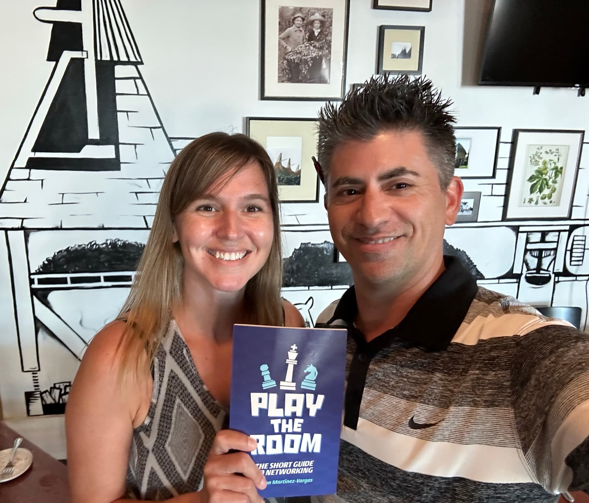 Dagan Martinez-Vargas with a reader holding a copy of Play the Room