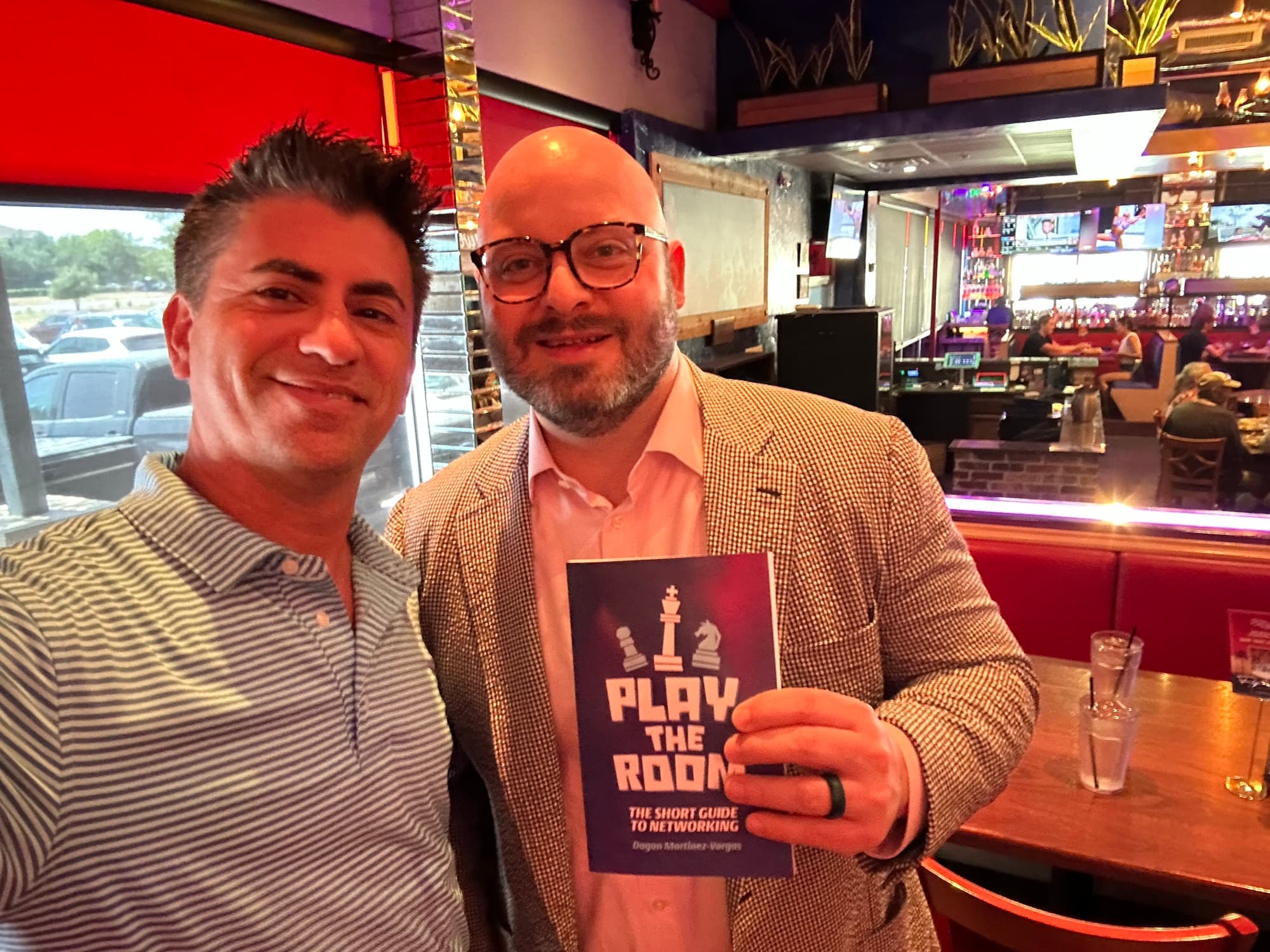 Dagan Martinez-Vargas with a reader holding a copy of Play the Room