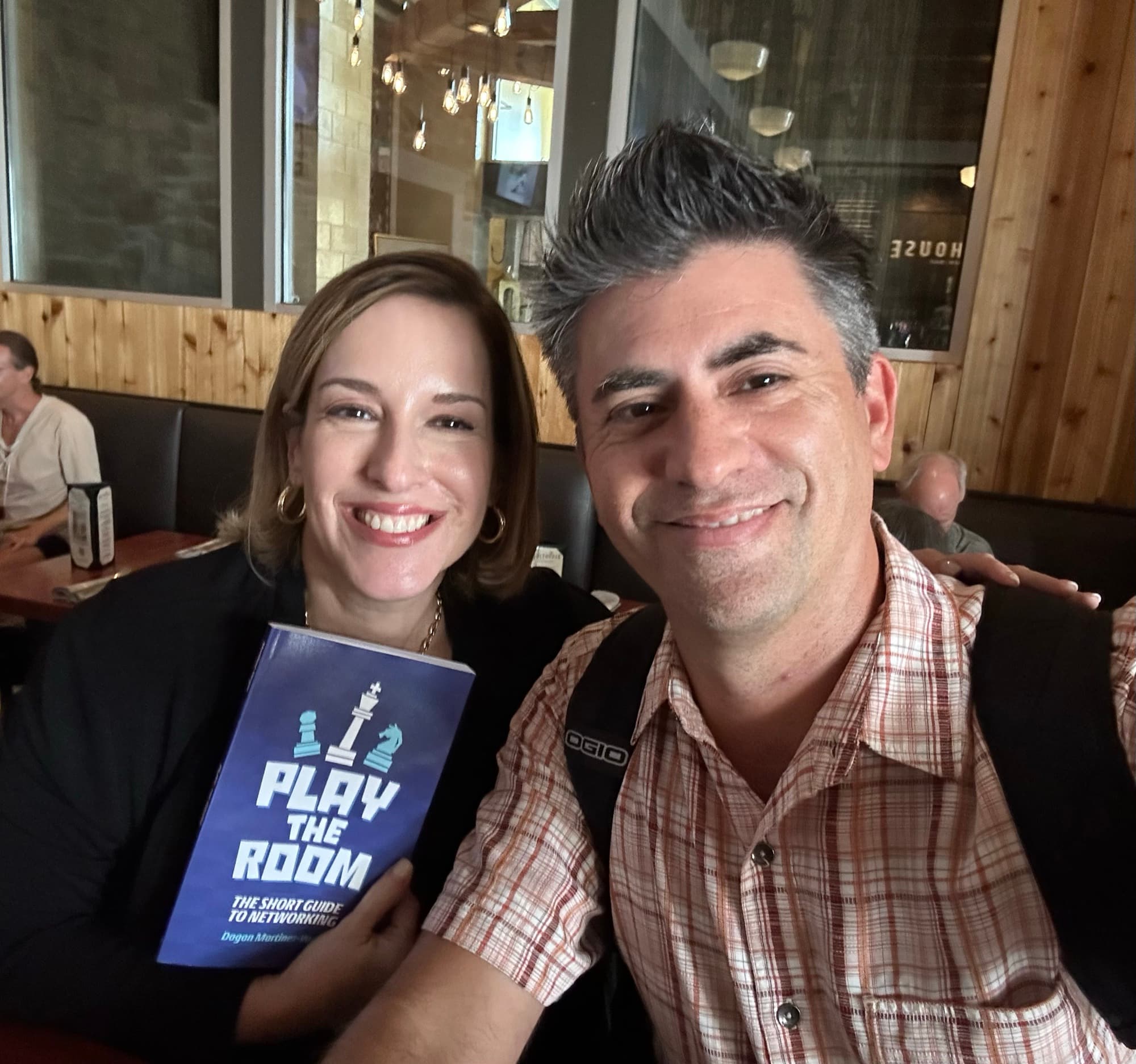 Dagan Martinez-Vargas with a reader holding a copy of Play the Room