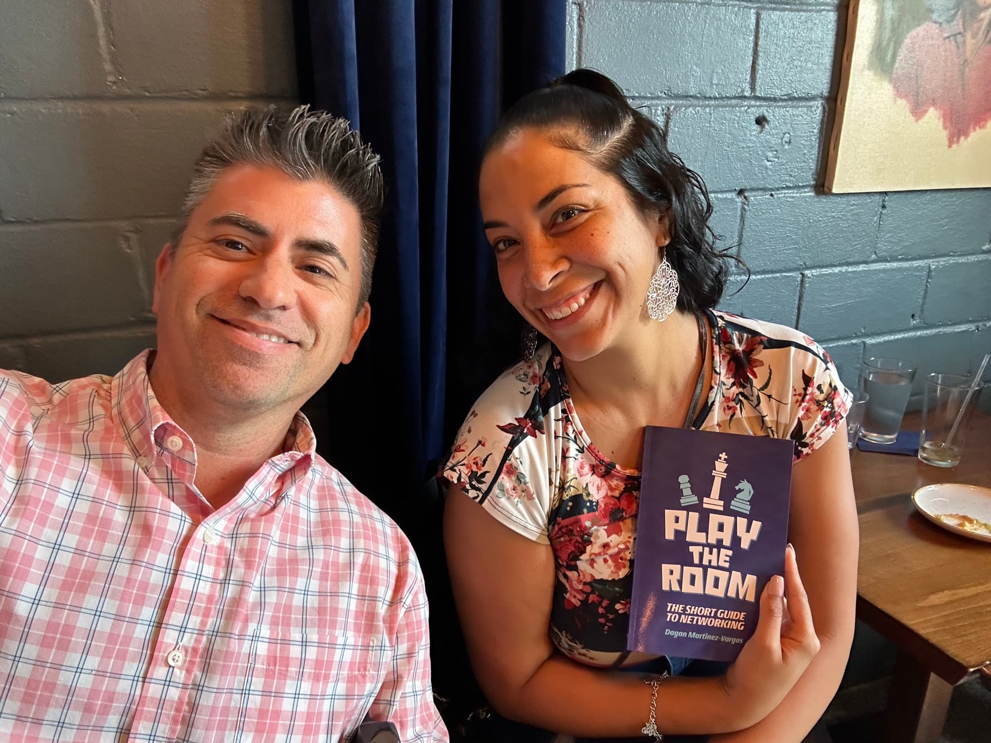 Dagan Martinez-Vargas with a reader holding a copy of Play the Room
