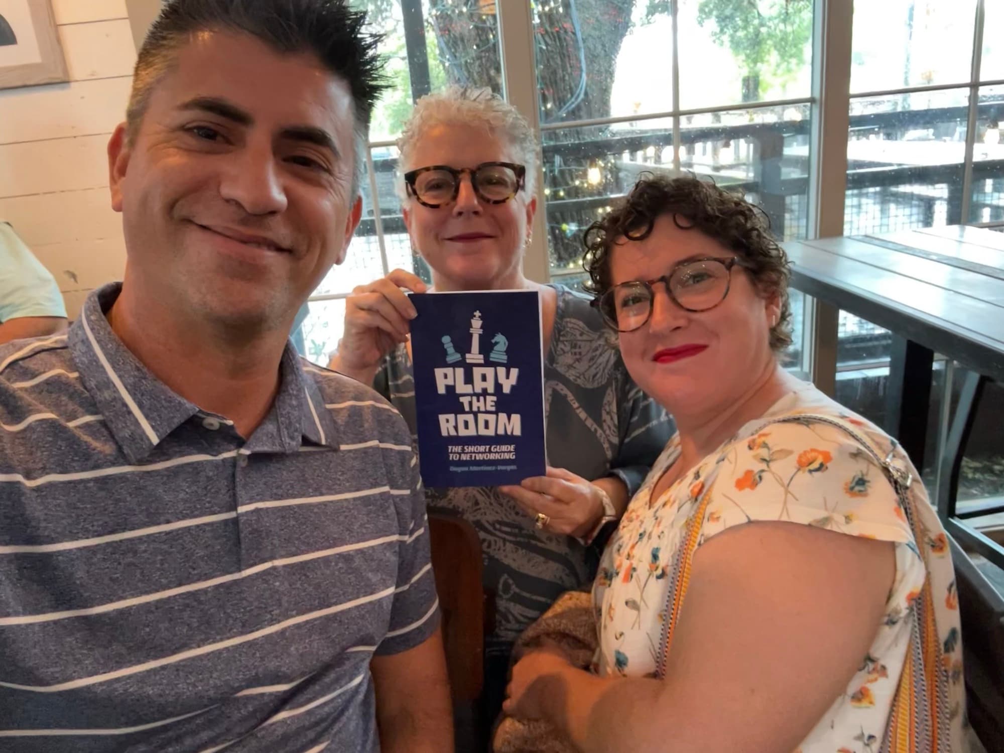 Dagan Martinez-Vargas with a reader holding a copy of Play the Room